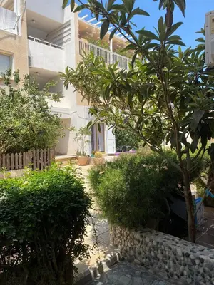 a garden with trees and bushes in front of a building at Stay With Oleg C17 in Paralimni