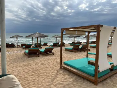 a beach with chairs and umbrellas on the sand at Villa suncity Boutique Beachfront in Ayia Napa