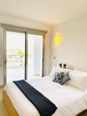 a bedroom with a large bed with a large window at The Penthouse 401 in Larnaka