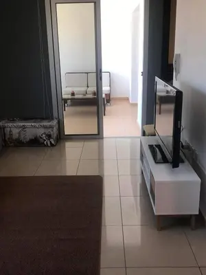 a living room with a mirror and a tv at Andris apartment in Paralimni