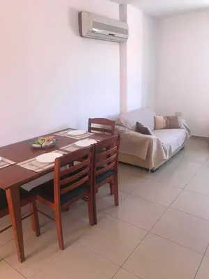 a dining room with a table and chairs and a couch at Andris apartment in Paralimni