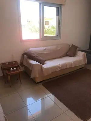 a bed in a room with a window and a table at Andris apartment in Paralimni