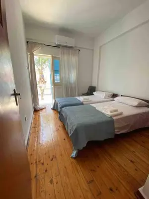two beds in a room with a wooden floor at 2 bedroom apt in Ermou 4 minute walk beach in Larnaka