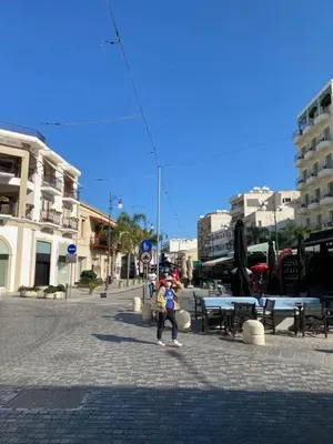 a woman walking down a street in a city at 2 bedroom apt in Ermou 4 minute walk beach in Larnaka
