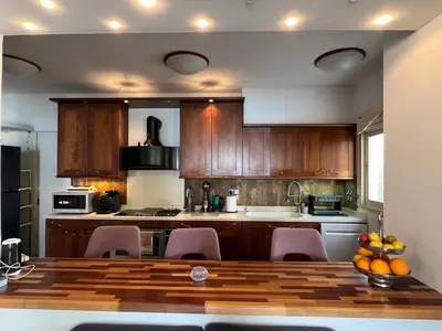 a kitchen with wooden cabinets and a table and chairs at SEA VIEW AMATHUS LUXURY APT in Limassol