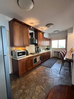 a kitchen with wooden cabinets and a stove top oven at SEA VIEW AMATHUS LUXURY APT in Limassol