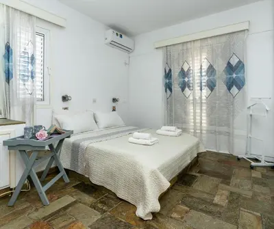 a white bedroom with two beds and a table at Blossom Holiday Villa DPS18 in Protaras
