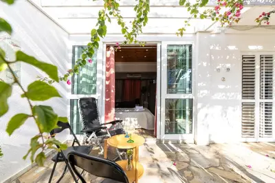 a room with a chair and a table with a television at Blossom Holiday Villa DPS18 in Protaras