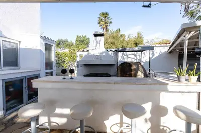 a outdoor kitchen with a grill and stools at Blossom Holiday Villa DPS18 in Protaras