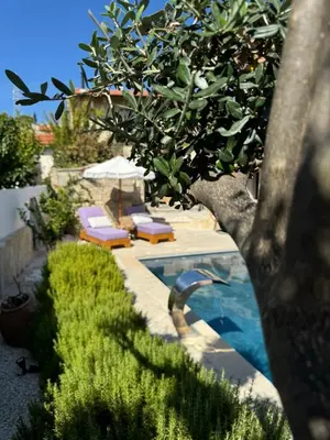 a swimming pool with two lounge chairs and an umbrella at Fig&Olive Luxury one bedroom boutique in Pachna in Limassol