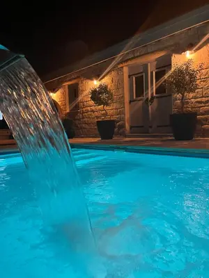 a water fountain in a pool at night at Fig&Olive Luxury one bedroom boutique in Pachna in Limassol