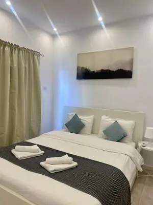 a bedroom with a large bed with towels on it at 1-bedroom duplex 100m by the sea in Limassol