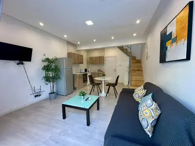 a living room with a couch and a table at 1-bedroom duplex 100m by the sea in Limassol