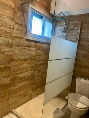 a bathroom with a toilet and a window at 1-bedroom duplex 100m by the sea in Limassol