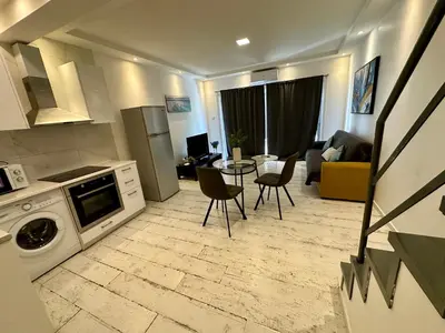 a kitchen and living room with a table and chairs at 1-bedroom duplex 100m by the sea in Limassol