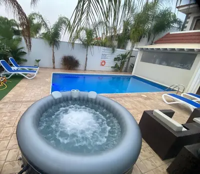 a hot tub on a patio next to a pool at Villa Angel - Exotic Villa 200m From Beach in Paralimni