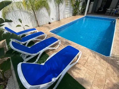 two blue and white chairs next to a swimming pool at Villa Angel - Exotic Villa 200m From Beach in Paralimni