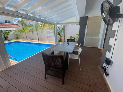 a patio with a table and chairs next to a pool at Villa Angel - Exotic Villa 200m From Beach in Paralimni