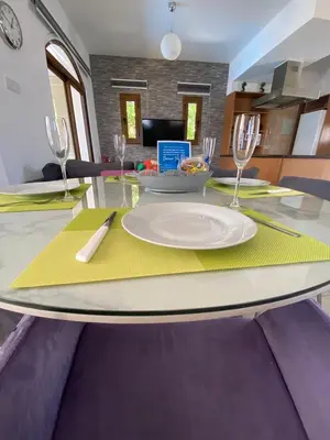 a dining table with a white plate on a yellow napkin at Villa Angel - Exotic Villa 200m From Beach in Paralimni