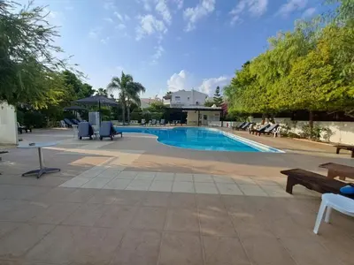 a swimming pool with lounge chairs and a bench at Limassol Star 6 in Limassol