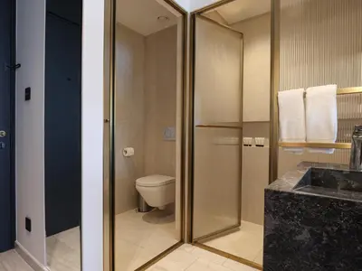 a bathroom with a toilet and a glass shower at The Nines in Ayia Napa
