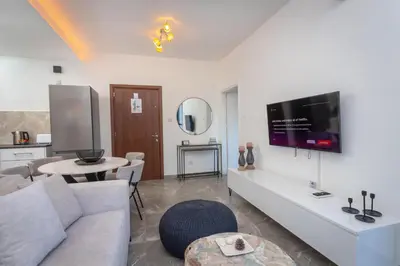 a living room with a couch and a tv at White Arches Apt #2 by TrulyCyprus in Limassol