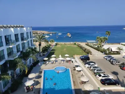 an aerial view of a resort with a swimming pool and the ocean at Dream Vacation by the Sea Protaras in Protaras
