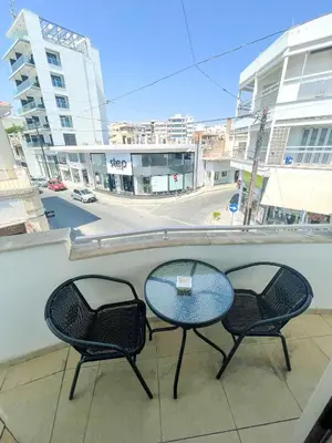 a table and two chairs sitting on a balcony at High Speed Holiday Apartment in Larnaka