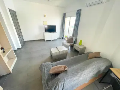 a bedroom with a bed and a living room at High Speed Holiday Apartment in Larnaka