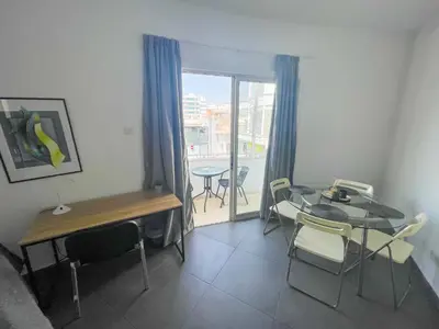 a room with a table and chairs and a window at High Speed Holiday Apartment in Larnaka
