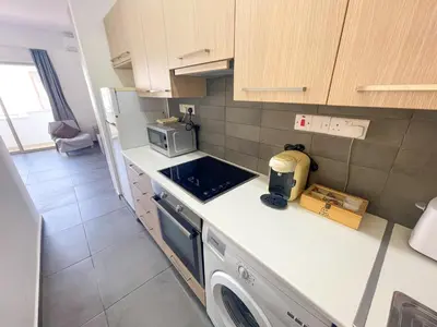 a kitchen with a sink and a stove top oven at High Speed Holiday Apartment in Larnaka