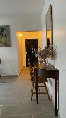 a dining room with a table and a mirror at T&L Apartments Germasogia in Limassol