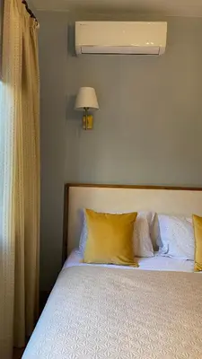 a bedroom with a bed with yellow pillows and a window at T&L Apartments Germasogia in Limassol