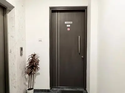 a brown door with a sign on it next to a plant at Albert's apartment St. Lazarus 401 in Larnaka