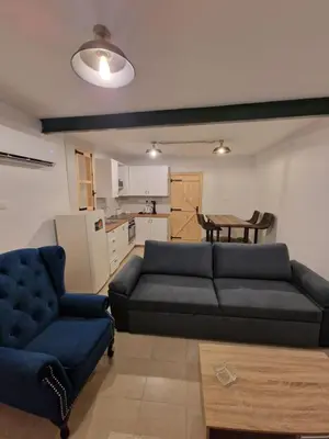 a living room with a blue couch and a kitchen at Aprosmeno Jacuzzi House 3 With Private Pool in Agros