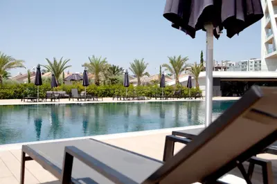 a swimming pool with chairs and umbrellas in a resort at Sky Tower in Limassol