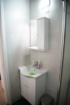 a white bathroom with a sink and a mirror at Cleo's Inn in Lofou