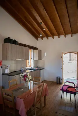 a kitchen with a table and chairs in a room at Cleo's Inn in Lofou