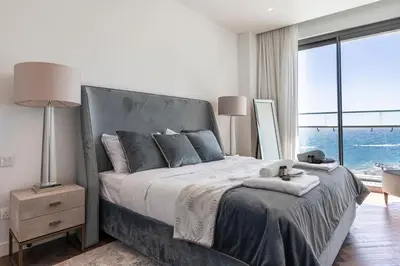 a bedroom with a large bed with a large window at Del Mar Beachfront 'C' 2 Bedroom Residence in Limassol