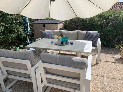 a white table and chairs with an umbrella at Bay Cottage Beautiful cosy luxury cottage - Beach area in Pissouri