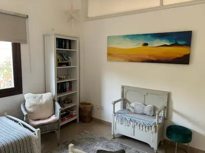 a room with a crib and a book shelf at Bay Cottage Beautiful cosy luxury cottage - Beach area in Pissouri
