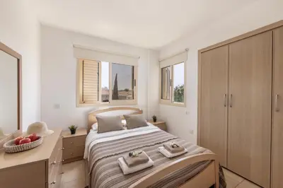 a bedroom with a bed with two towels on it at Pelagos apartment 6 in Paralimni