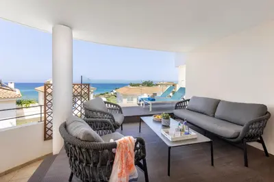 a living room with a couch and chairs on a balcony at Pelagos apartment 6 in Paralimni