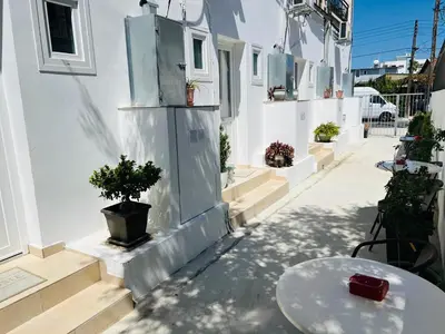 a white building with a table and a potted plant at Cozy and Traditional - EC Studios in Larnaka