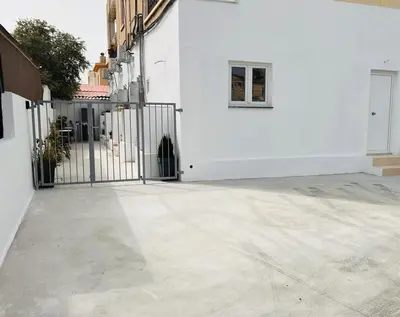 a white building with a gate and a window at Cozy and Traditional - EC Studios in Larnaka