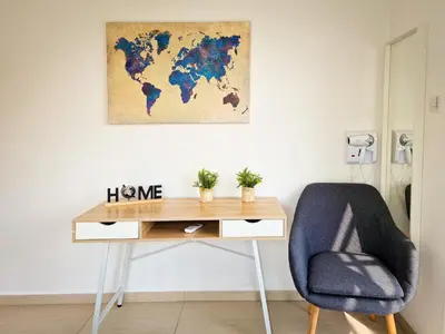 a desk with a chair and a world map on the wall at Villa Green garden in Ayia Napa