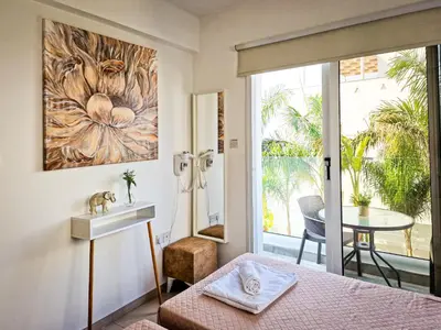 a bedroom with a bed and a sink and a table at Villa Green garden in Ayia Napa