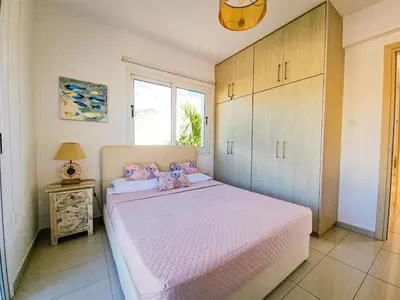 a bedroom with a large bed with pink sheets at Nissi beach villa Oleandra in Ayia Napa