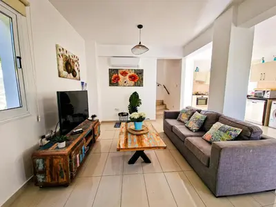 a living room with a couch and a coffee table at Nissi beach villa Oleandra in Ayia Napa