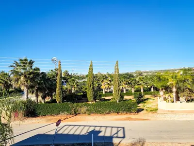 a view of a park with palm trees and the ocean at Nissi beach villa Oleandra in Ayia Napa